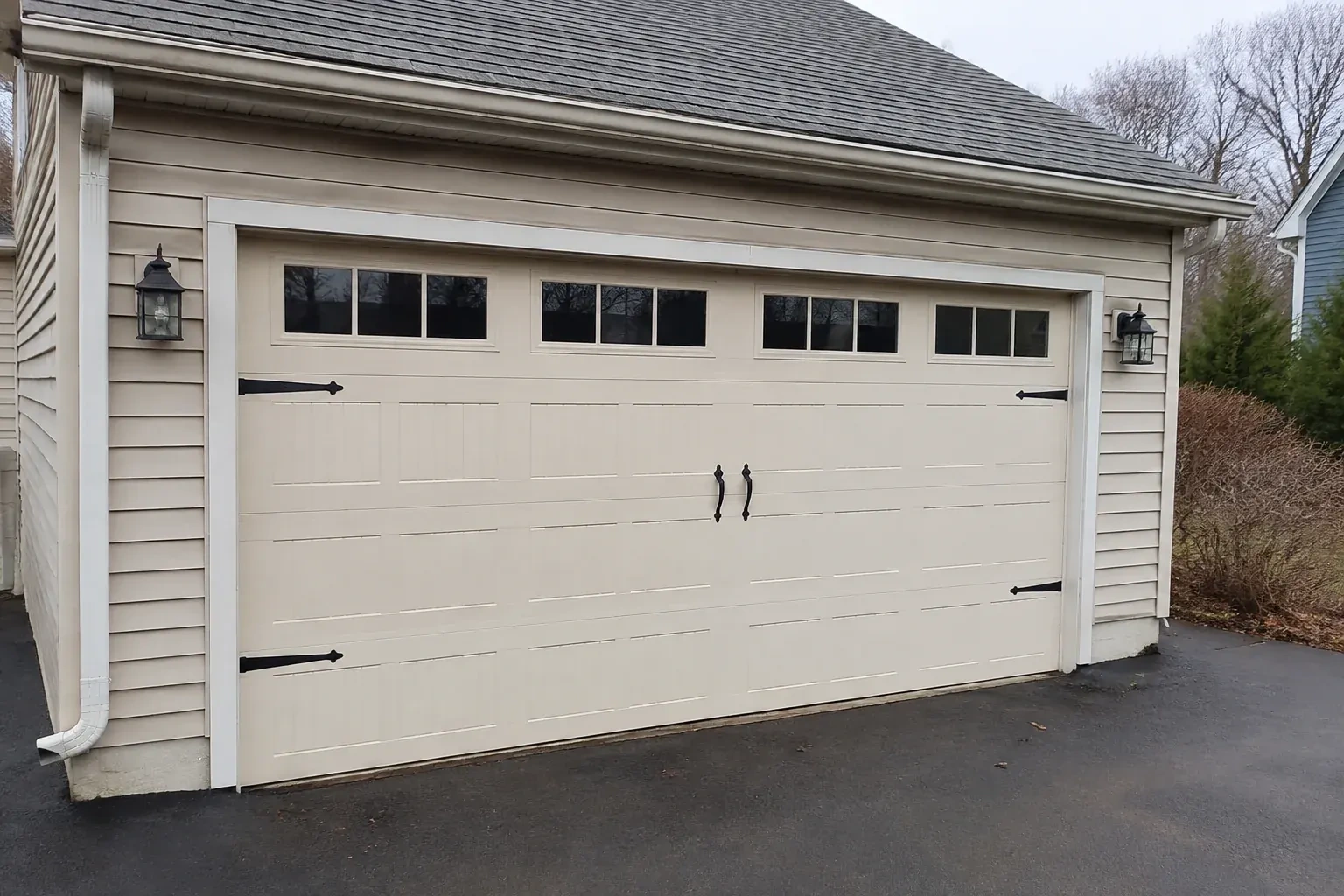 Cream carriage-house-style garage door with dark decorative hardware. — Carriage-House Garage Door Installation, Strathroy-Caradoc