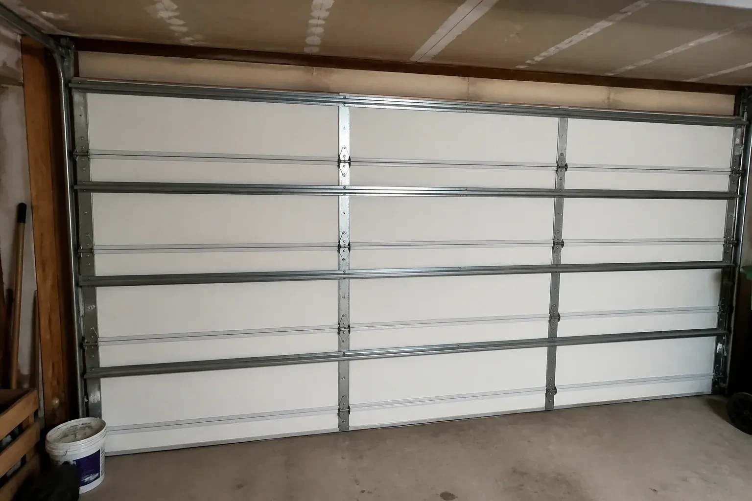 Interior of a closed sectional door with horizontal metal reinforcement struts. — Wind-Rated Garage Door Replacement, Strathroy-Caradoc